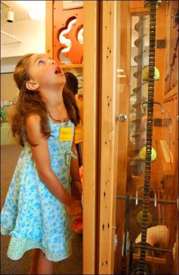 Child using kid power machine exhibit